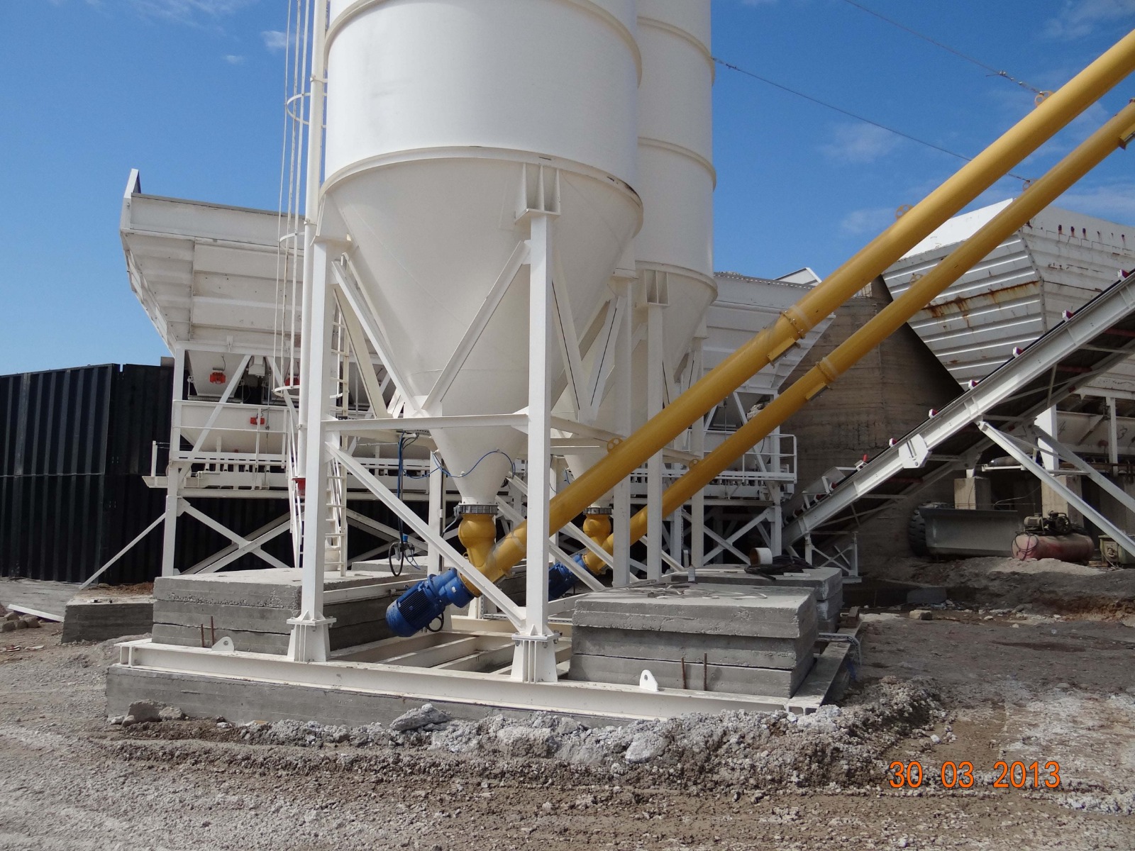 Yellow inclined screw conveyors beneath silo outlets